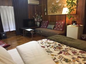 uma sala de estar com uma cama e um sofá em Shirahama Hotel em Nago