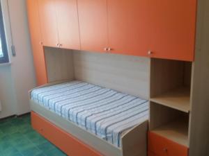 ティレニアにあるNettuno Apartamentのオレンジ色のキャビネットが備わる客室の小さなベッド1台分です。