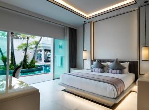 a bedroom with a large bed and a pool at Chanalai Romantica Resort - Adults Only, Kata Beach in Kata Beach +72 photos