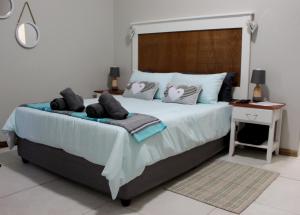 a bedroom with a large bed with pillows on it at Tranquility Self Catering in Lüderitz