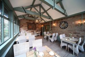 a restaurant with tables and chairs and a clock on the wall at Weston Hall in Stafford