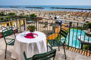 einen Tisch auf einem Balkon mit Blick auf den Strand in der Unterkunft Hotel Estate in Rimini