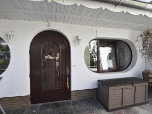 a building with a brown door and a window at Homey Bungalow with Roofed Terrace Garden Garden Furniture in Neubukow