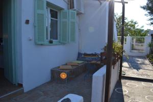 a white building with a window and a table and chairs at Skyros Panorama Studios in Skiros