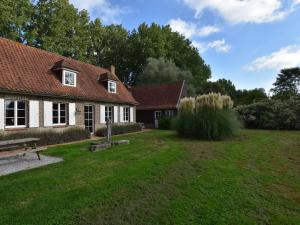 a house with a bench and a grass yard at Beautiful holiday home with sauna in Saint-Omer