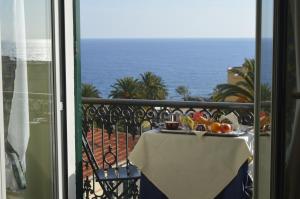 a table with a plate of fruit on a balcony at Hotel Morandi in Sanremo