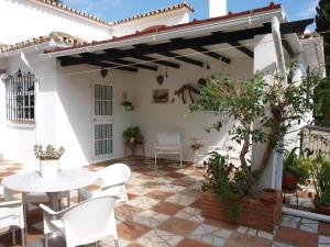 a patio of a house with a table and chairs at Finca Villordo Villa Tranquila in Benalmádena