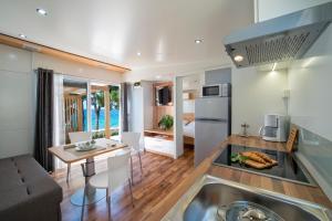 kuchnia i salon z kanapą i stołem w obiekcie Adria Village Superior Mobile Homes w Pakoštane