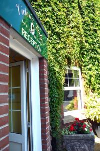 a building with a sign that reads reception at Victoria Lodge Guest House in Salisbury