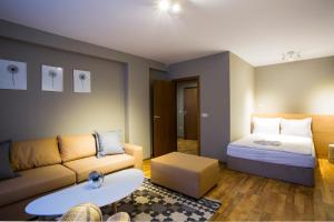 a living room with a couch and a bed at Sunny Hills Ski&Wellness in Pamporovo