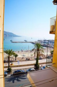 a view of a beach with palm trees and the ocean at Les Sablettes in Menton