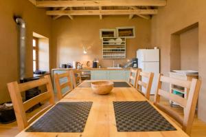 a kitchen with a wooden table with a bowl on it at Serene Stone House in Oxiá