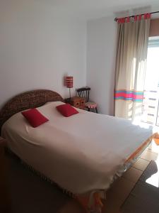 uma grande cama branca num quarto com uma janela em Cabanas Pool Apartment em Cabanas de Tavira