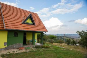 a green and yellow house with a red roof at Vikendica MM in Zlatibor
