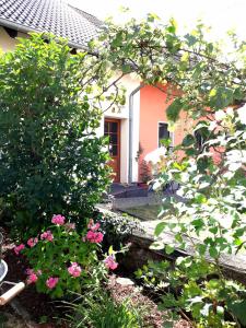 uma casa com flores cor-de-rosa em frente em Ferienwohnung Adams em Hinterweiler