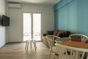 アテネにあるComfort Zone Apartment in the heart of Athensのリビングルーム(テーブル、椅子、ソファ付)