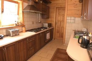 a kitchen with wooden cabinets and a stove top oven at U Zbyszka in Białka Tatrzańska