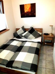 Schlafzimmer mit einem Bett mit schwarzer und weißer Bettwäsche in der Unterkunft Ferienwohnung Adams in Hinterweiler