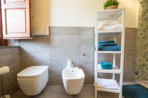 uma casa de banho com um WC branco e um lavatório. em Sicily's View em Mascalucia