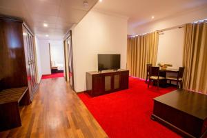 sala de estar con TV y alfombra roja en Trillium Boutique City Hotel en Colombo