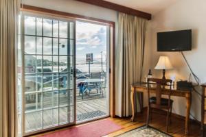 a hotel room with a desk and a sliding glass door at Ocean Cove Inn in Yachats