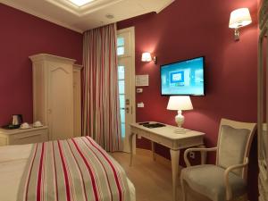 a living room with a television and a bed at Relais Le Chevalier in Riga