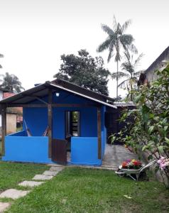 una casa azul con porche y patio en Chalé saí azul en Penedo