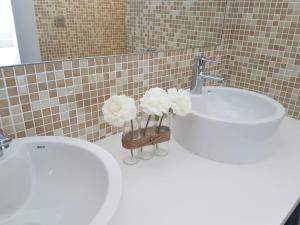 ein Bad mit einem Waschbecken und einem WC mit Blumen in einem Korb in der Unterkunft Vivienda Tauro in Puerto del Carmen + 20 Fotos