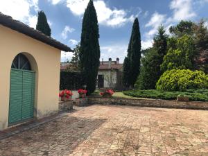a courtyard of a house with a green door at Casa di Romano, La Piazzetta in Tavarnelle in Val di Pesa