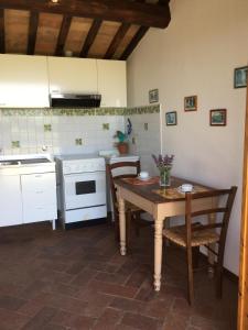 uma cozinha com uma mesa de madeira, uma mesa e cadeiras em Casa di Romano, La Piazzetta em Marcialla