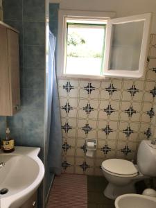 a bathroom with a toilet and a sink and a window at Villa Mariapia in Fontane Bianche