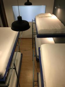 a room with three bunk beds and a lamp at Hobu Hostel in Bogotá