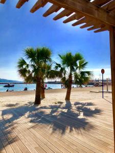 two palm trees on a beach near the water at Les Sablettes in Menton