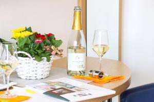 a bottle of wine and a vase of flowers on a table at Haus Mariella in Podersdorf am See