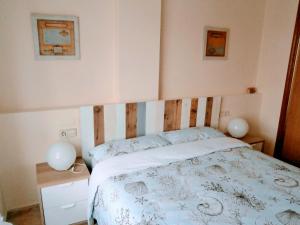 パロス岬にあるCala AZUL Gran Terraza con BBQのベッドルーム1室(木製ヘッドボード付きのベッド1台付)