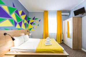 利維夫的住宿－Blum Hotel，一间卧室设有一张床和色彩缤纷的墙壁
