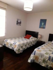 a bedroom with two beds and a red folder on the bed at Apartamentos Amoblados de 1 Y 2 dormitorios in Lima