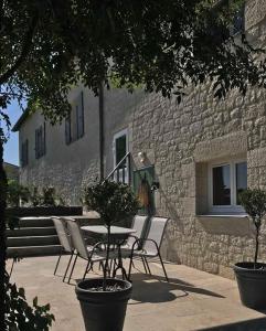 a table and chairs in front of a stone building at Le Domaine des Terres Blanches in Le Boulvé