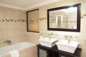 a bathroom with two sinks and a tub and a mirror at Destiny Lodge in White River