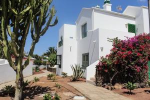 una casa bianca con fiori rosa di fronte di Casa Real a Playa Blanca