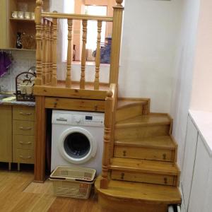 una lavatrice in una cucina con scala in legno di Квартира в Ичери шехер a Baku