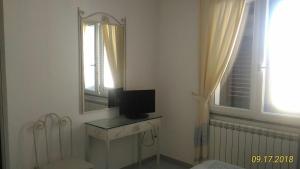 a bathroom with a mirror and a television on a table at B&B Madau in Samughèo