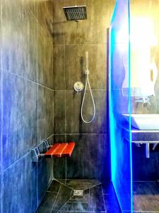 a bathroom with a shower with a bench and a sink at Rooms Gli arcangeli 2 - Affitti Brevi Italia in Monte SantʼAngelo