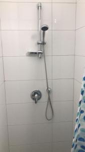 La salle de bains est pourvue d'une douche avec un pommeau de douche. dans l'établissement Isramax apartment near the beach., à Bat Yam