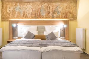 a bedroom with a large bed with a painting above it at Hotel & Restaurant Sparta in Oldenburg