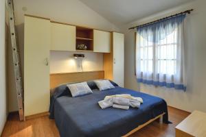 a bedroom with a blue bed with towels on it at Holiday Home Monica in Banjole