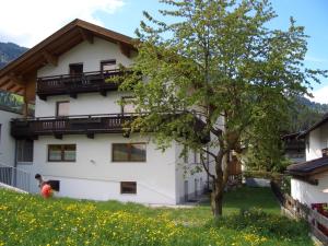 ein Gebäude mit einem Baum davor in der Unterkunft Appartements Hirner in Fügen