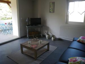 Sala de estar con sofá azul y mesa de centro en La maison des Prouges, en Fuissé