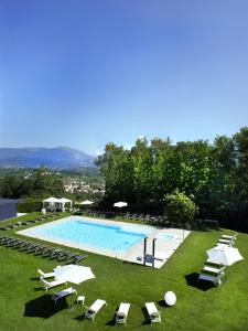 a large swimming pool with lounge chairs and umbrellas at Relais Le Betulle in Conegliano