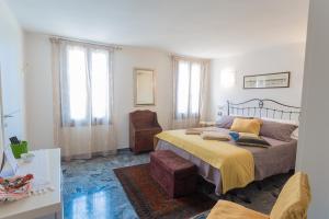 een slaapkamer met een bed en een stoel erin bij B&B Antico Orologio in Chioggia